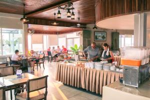 a group of people sitting at tables in a restaurant at Paradise Hotel in Phnom Penh
