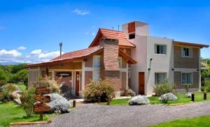 una casa con una señal de carretera delante de ella en El Portillo en Villa General Belgrano