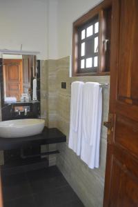 uma casa de banho com lavatório, espelho e toalhas em Hotel Golden Ray em Dambulla
