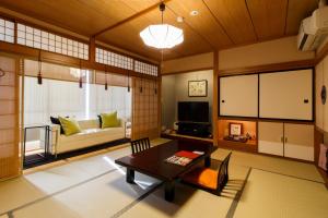 uma sala de estar com uma mesa e um sofá em Oyado Koto No Yume em Takayama