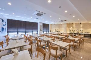 a restaurant with tables and chairs in a room at Gwangju Aura Hotel in Gwangju