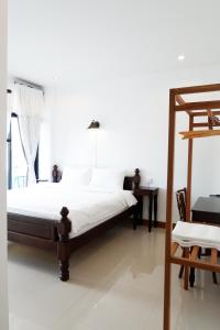 1 dormitorio blanco con 1 cama y 1 silla en Rimnim Hostel, en Chiang Mai