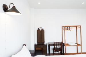 a bedroom with a bed and a desk and a mirror at Rimnim Hostel in Chiang Mai
