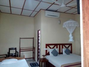 a bedroom with two beds and a ceiling at Ruins View Holiday Resort in Polonnaruwa