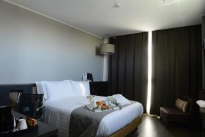 a hotel room with a bed and a television at Best Western Premier CHC Airport in Genoa