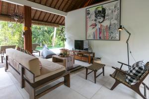 a living room with a couch and a chair at Villa Sunari Ubud in Ubud