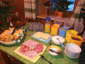 een tafel met brood, vlees en borden met voedsel bij Hoazhof in Kals am Großglockner