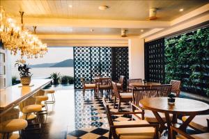 - un restaurant avec des tables et des chaises et une vue sur l'océan dans l'établissement The Beach Samui, à Taling Ngam Beach