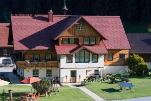 uma casa grande com telhado vermelho em Forsterhof em Ramsau am Dachstein