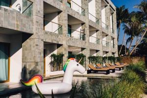 a unicorn float in the water in front of a building at The Beach Samui - SHA Extra Plus in Taling Ngam Beach