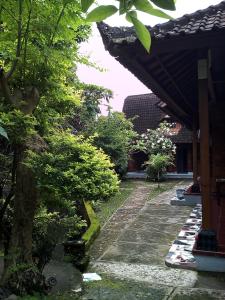 a garden with a stone walkway next to a building at Madra Homestay in Ubud