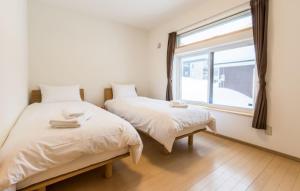 倶知安町にあるロッジ　モリ　アパートメントの窓のある部屋にベッドが2つある