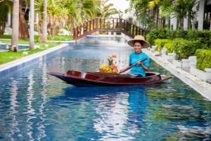 una mujer está remando un barco en el agua en Access Resort & Villas - SHA Plus, en Karon Beach