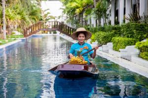 una mujer en un barco con un montón de bananas en Access Resort & Villas - SHA Plus, en Karon Beach