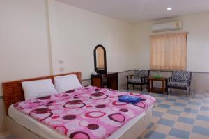 een slaapkamer met een groot bed en een roze deken bij Purinplace in Pluak Daeng