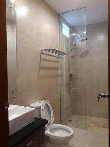 a bathroom with a shower and a toilet and a sink at Puri Kesari Guest House in Sanur