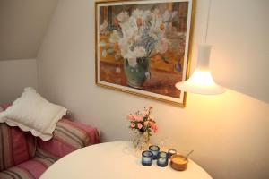uma mesa com um vaso de flores e uma pintura em Willes B&B em Copenhague