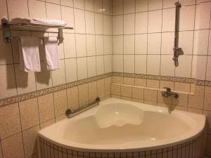 台北的住宿－東姿商務旅館，带浴缸和毛巾的瓷砖浴室