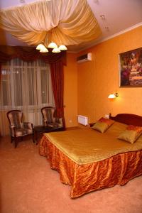 ein Hotelzimmer mit einem großen Bett und Stühlen in der Unterkunft Oazis Hotel in Saratow