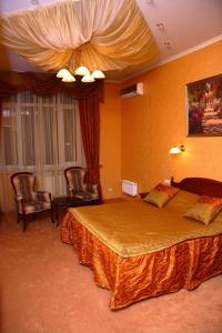 a hotel room with a large bed and chairs at Oazis Hotel in Saratov