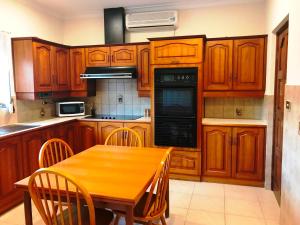 a kitchen with wooden cabinets and a wooden table with chairs at Adelaide's holiday home in Modbury
