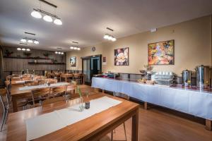 un ristorante con tavoli in legno e un bar di Penzion Limba a Liptovský Ján