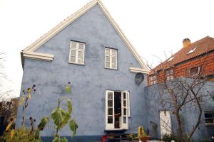 a blue house with white windows and a brick building at Willes B&B in Copenhagen