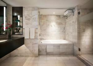 a bathroom with a bath tub and a sink at PARKROYAL Penang Resort in Batu Ferringhi