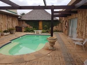 a swimming pool in a patio with a table and chairs at Kleinplaas Guest Farm in Potchefstroom