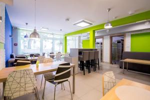 a restaurant with tables and chairs and green walls at Dom Studenta AŁ in Łomża