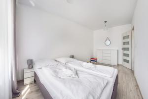 シフィノウイシチェにあるApartamenty Sun & Snow Kwartał Róży Wiatrówの白いベッドルーム(白いシーツ付きのベッド2台付)