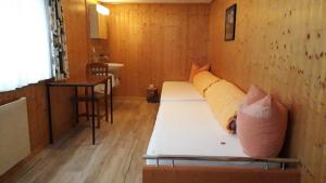 een kleine kamer met een bed met kussens erop bij Tschuggen Apartment - No Kitchen in Grindelwald
