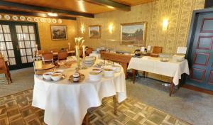 een eetkamer met twee tafels met gerechten erop bij Hotel St. Binderup in Store Binderup