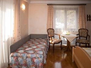 1 dormitorio con 1 cama, mesa y sillas en Pension Handle en Kramsach