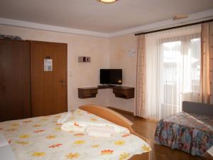 um quarto com uma cama e uma televisão em Pension Handle em Kramsach