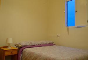 una camera da letto con un letto e una finestra blu di Peris Mencheta a Siviglia