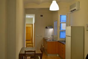 una cucina con frigorifero, tavolo e sedie di Peris Mencheta a Siviglia