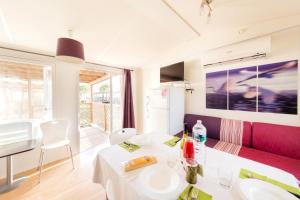 a living room with a white table and a red couch at Riva Nuova Camping Village in Martinsicuro