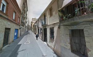 a person walking down a street in an alley at Fraternitat SDB in Barcelona