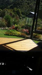 a wooden deck with flowers in a garden at The Red Shed, Anakiwa in Picton