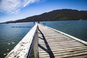 a wooden bridge over a body of water at The Red Shed, Anakiwa in Picton