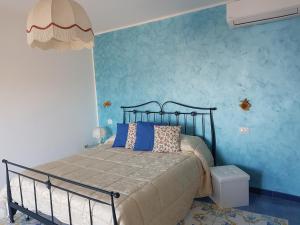 a bedroom with a bed and a blue wall at B&B Oliva in Scala