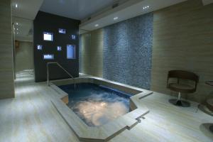 a hot tub in a room with a chair at Bass Boutique Hotel in Yerevan