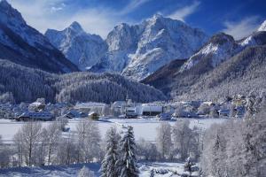 a village in the snow with mountains in the background at Skier's cave in Kranjska Gora +5 photos