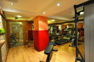 a gym with treadmills and bikes in a room at Adults only Hotel Grafenstein in Schenna