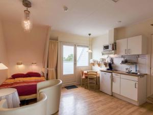 1 dormitorio con 1 cama y cocina con mesa en Unique studio on large estate with sea view, en Bergen aan Zee