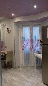 eine Küche mit einer Glasschiebetür, einem Tisch und einem Kühlschrank in der Unterkunft B&B Tre passi CIR 23091 in Verona