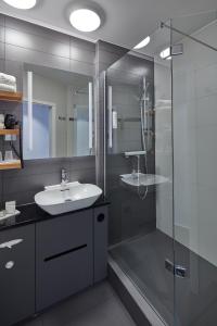 a bathroom with a sink and a glass shower at Landhotel Naafs-Häuschen in Lohmar +33 photos