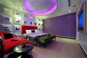 Roman Vacation Motel في Dali: غرفة نوم بسرير وجدار ارجواني