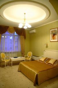 ein Schlafzimmer mit einem großen Bett und einem Tisch in der Unterkunft Oazis Hotel in Saratow